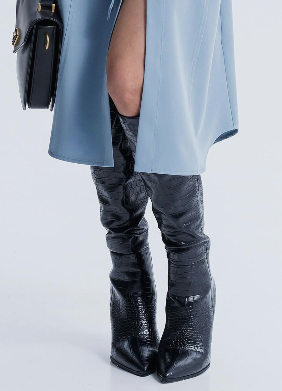 Diverse shoe collection featuring elegant heels and a range of boots including ankle, knee-high, and combat styles.